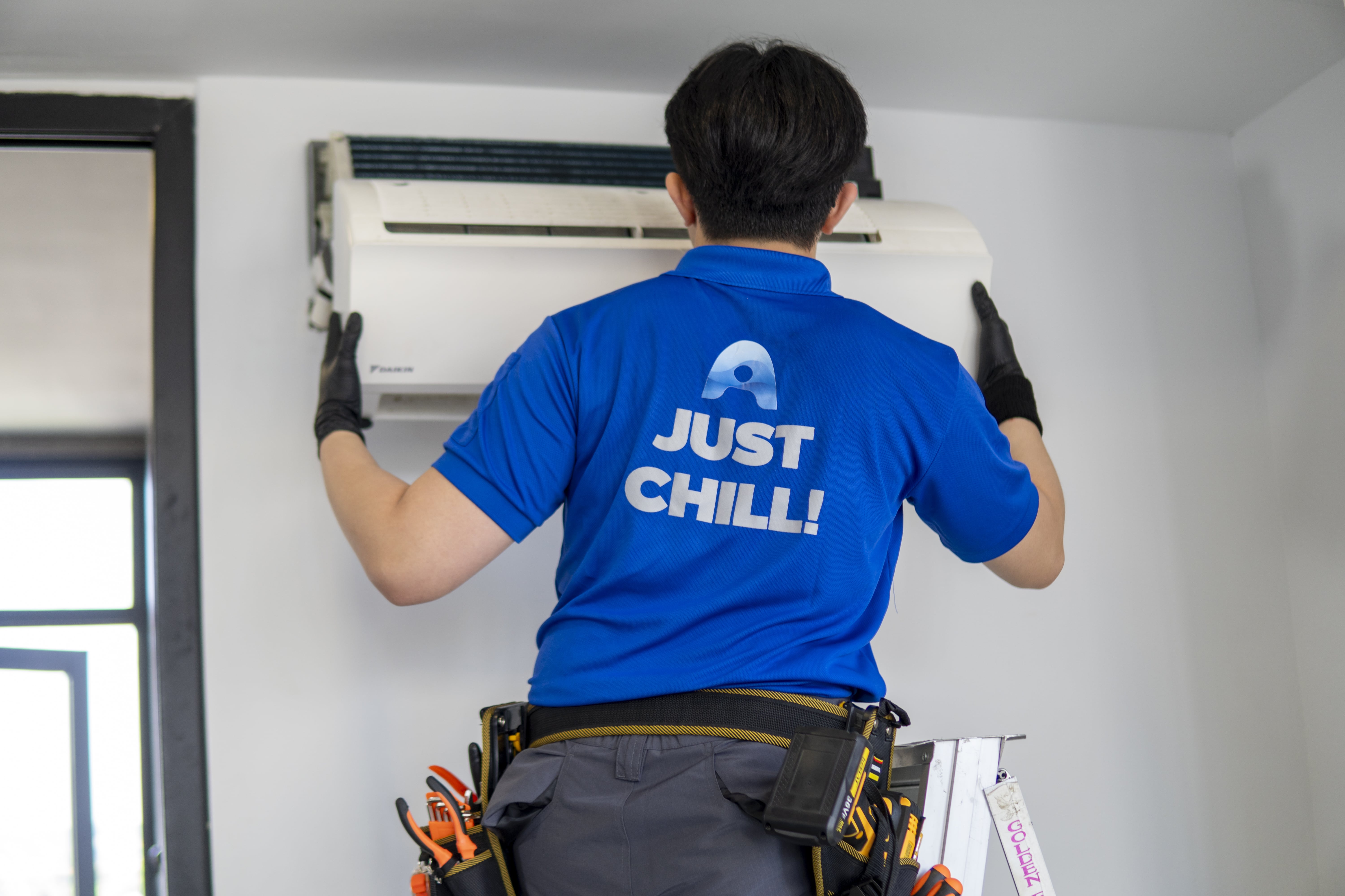 Airple technician servicing an air conditioner unit